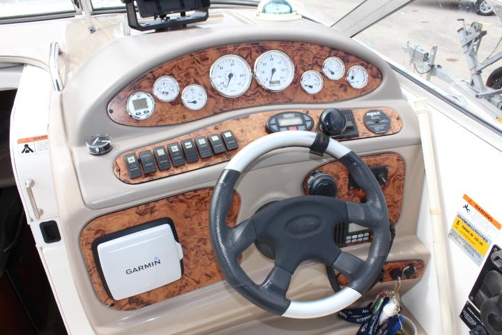 2005 Larson Cabrio 240 boat dashboard with Garmin GPS and woodgrain finish.