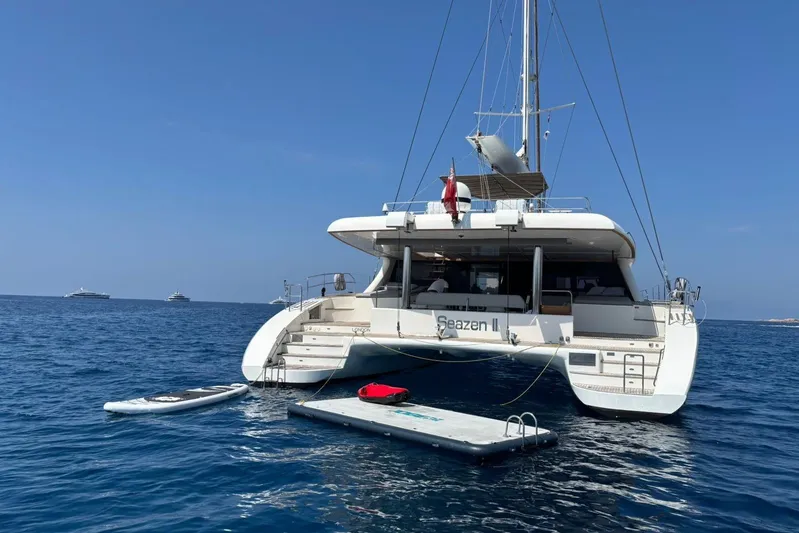 Seazen II Yacht Photos Pics Sunreef 70 catamaran from 2008 anchored at sea with paddleboard and floating platform.