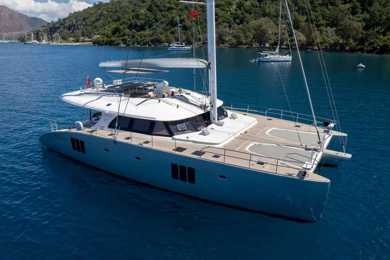 Seazen II Yacht Photos Pics Luxurious 2008 Sunreef 70 yacht sailing in serene blue waters near lush coastline.
