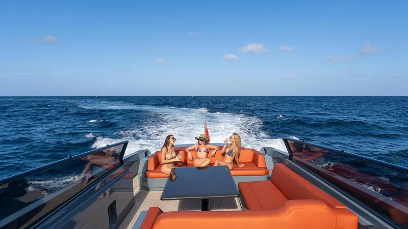 Vesper Yacht Photos Pics 2017 Vanquish Yachts VQ 54 cruising with passengers, featuring luxurious orange seating and ocean backdrop.