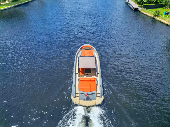 Vesper Yacht Photos Pics Aerial view of 2017 Vanquish Yachts VQ 54 cruising on a serene waterway.