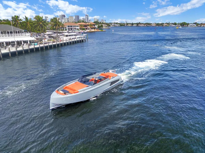 Vesper Yacht Photos Pics Vanquish Yachts VQ 54 (2017) cruising on a sunny waterfront with cityscape background.