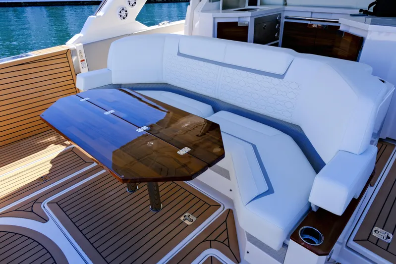 Feeling Knotty Yacht Photos Pics Luxurious seating area on 2023 Tiara Yachts 48 LS with elegant wooden table.