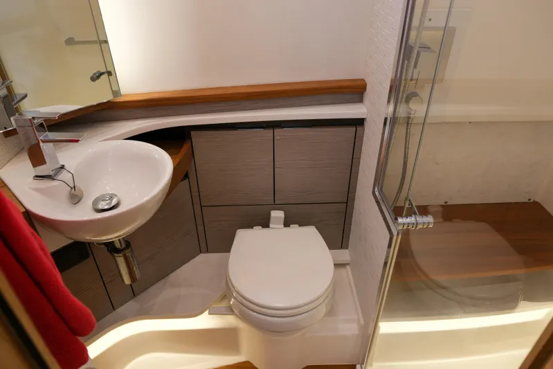 Feeling Knotty Yacht Photos Pics 2023 Tiara Yachts 48 LS bathroom with modern sink, toilet, and shower.