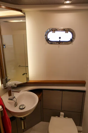 Feeling Knotty Yacht Photos Pics 2023 Tiara Yachts 48 LS bathroom with modern sink and porthole window.