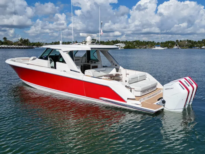 Feeling Knotty Yacht Photos Pics 2023 Tiara Yachts 48 LS in vibrant red, docked on a sunny day.