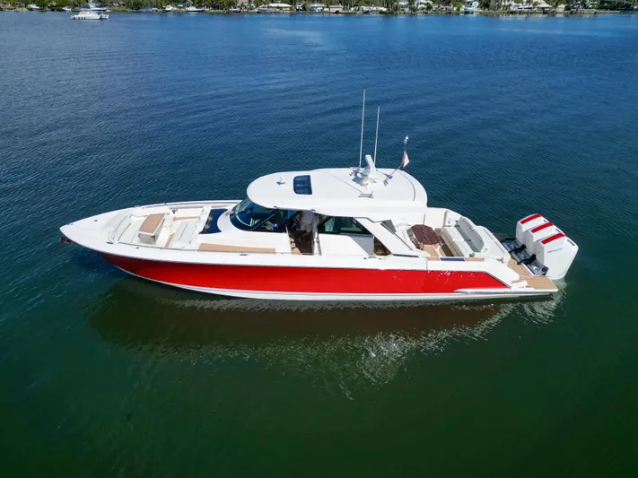 Feeling Knotty Yacht Photos Pics 2023 Tiara Yachts 48 LS in vibrant red on calm water.
