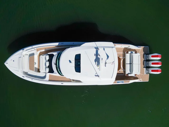 Feeling Knotty Yacht Photos Pics Aerial view of 2023 Tiara Yachts 48 LS on water, showcasing sleek design and triple engines.