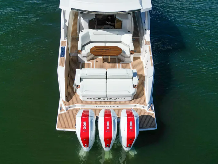 Feeling Knotty Yacht Photos Pics 2023 Tiara Yachts 48 LS with triple 600 HP engines, rear view on water.