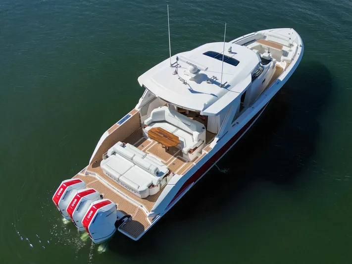 Feeling Knotty Yacht Photos Pics 2023 Tiara Yachts 48 LS luxury boat with triple outboard engines on calm water.