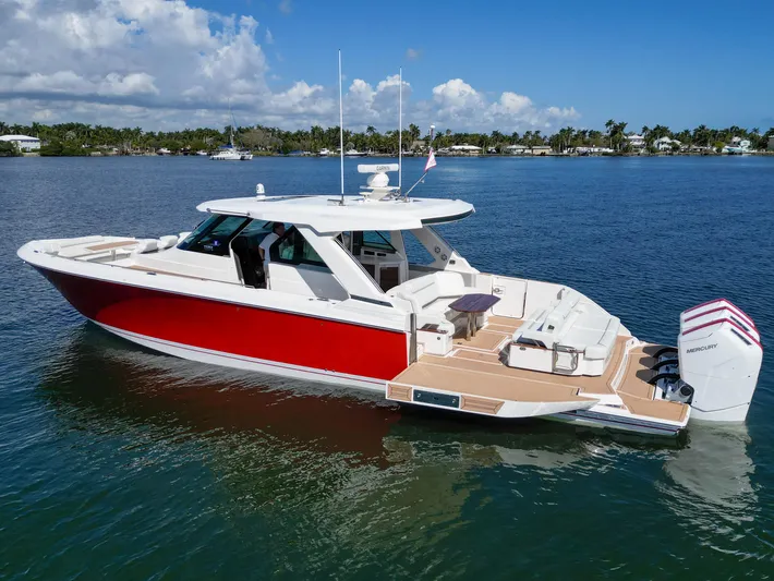 Feeling Knotty Yacht Photos Pics 2023 Tiara Yachts 48 LS, red and white luxury boat on calm water.