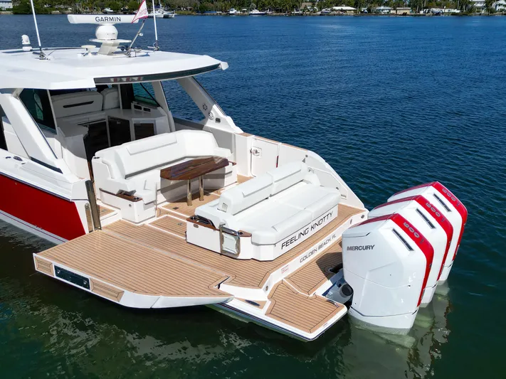 Feeling Knotty Yacht Photos Pics 2023 Tiara Yachts 48 LS with triple Mercury engines, spacious deck, and luxurious seating.