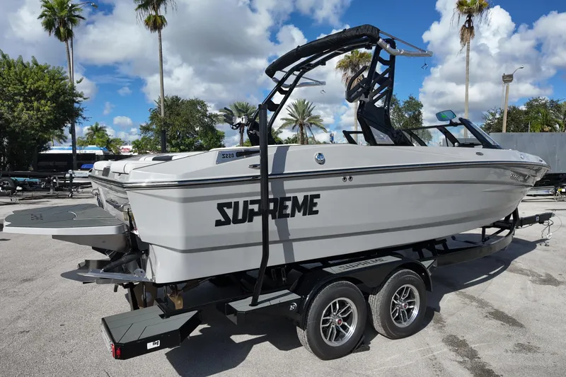  Yacht Photos Pics 2025 Supreme S220 boat on trailer, parked outdoors under a clear sky.