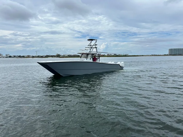 Necessity Yacht Photos Pics 2018 Freeman 42LR boat cruising on calm waters under a cloudy sky.