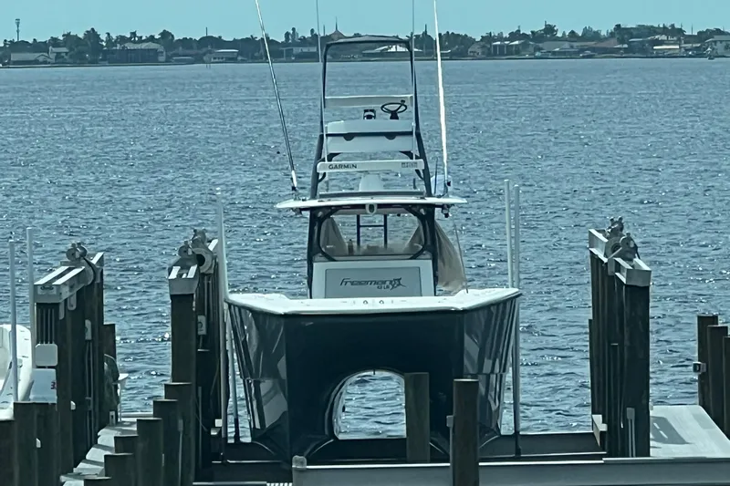Necessity Yacht Photos Pics Freeman 42LR 2018 boat docked on calm water with distant shoreline.