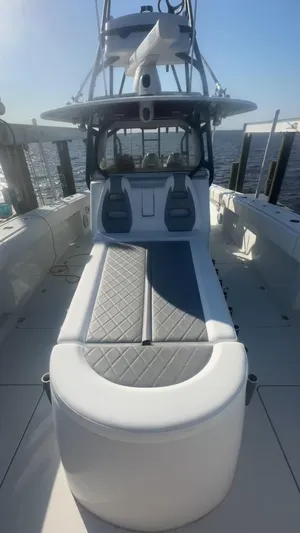Necessity Yacht Photos Pics 2018 Freeman 42LR boat with cushioned seating, docked by the water.