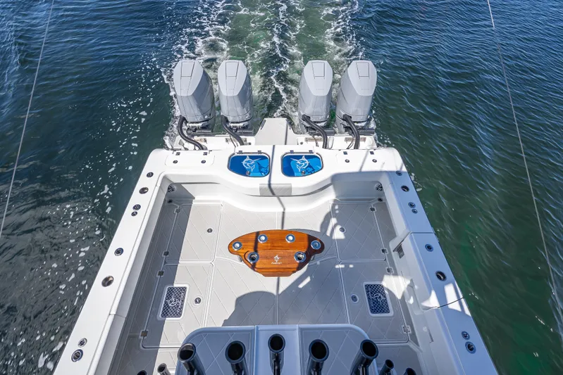  Yacht Photos Pics 2024 Freeman 43 boat with quad engines, spacious deck, and fishing rod holders on water.