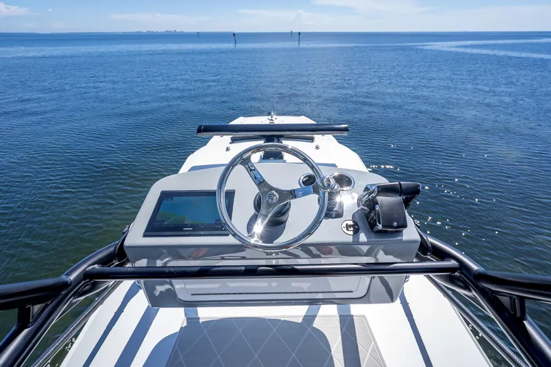  Yacht Photos Pics 2024 Freeman 43 boat helm with steering wheel and navigation screen on open water.
