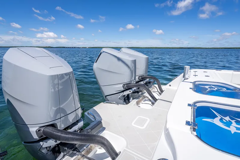  Yacht Photos Pics 2024 Freeman 43 boat with dual outboard engines on a calm sea.