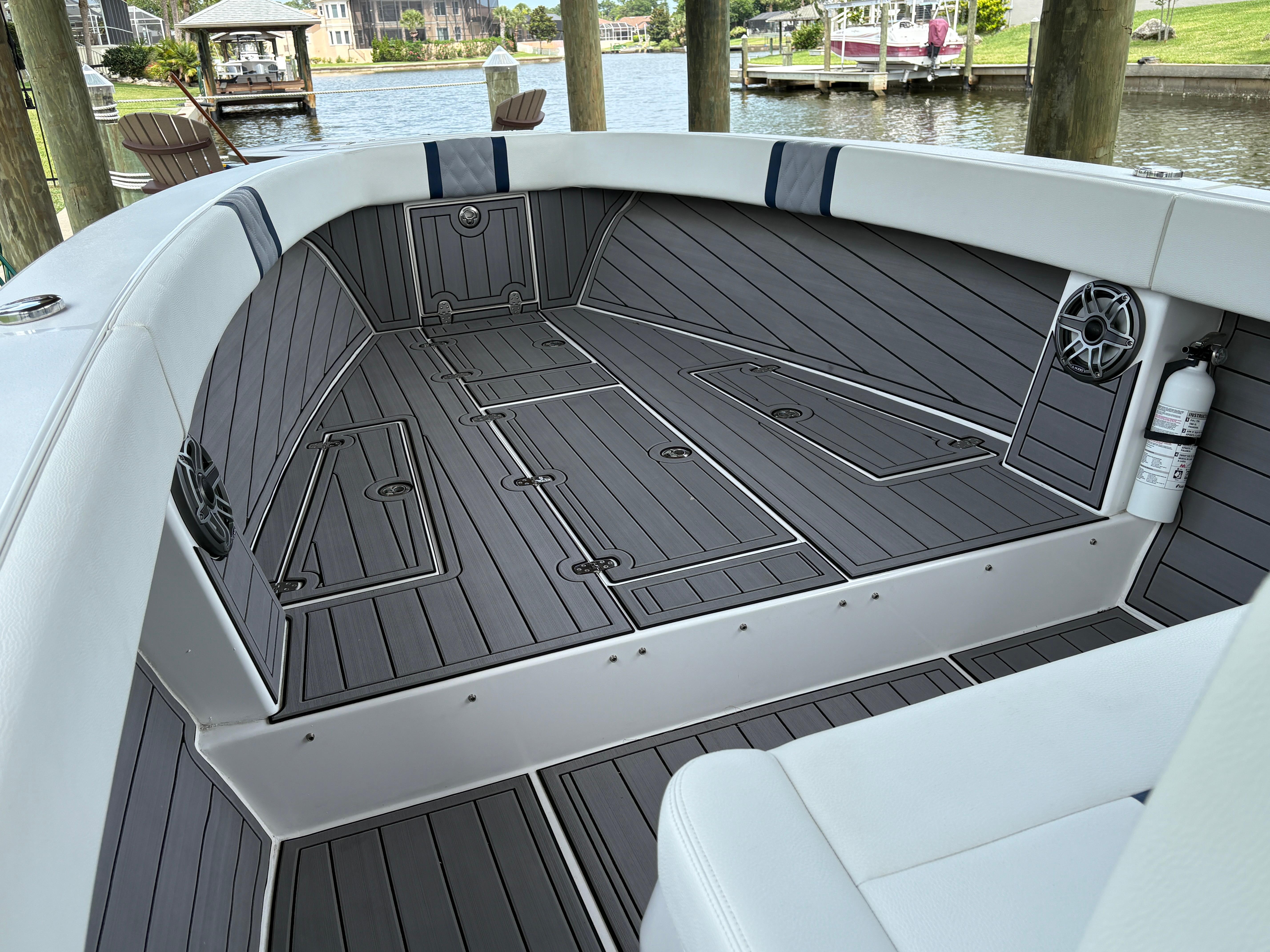 Interior of 2023 Action 25 boat with sleek gray flooring and seating by the water.