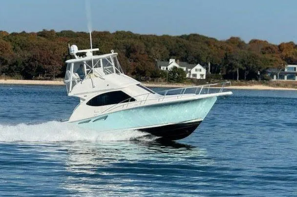 Follow That Stern Ix Yacht Photos Pics 2007 Tiara Yachts 3900 Convertible cruising on a serene lake near a wooded shoreline.