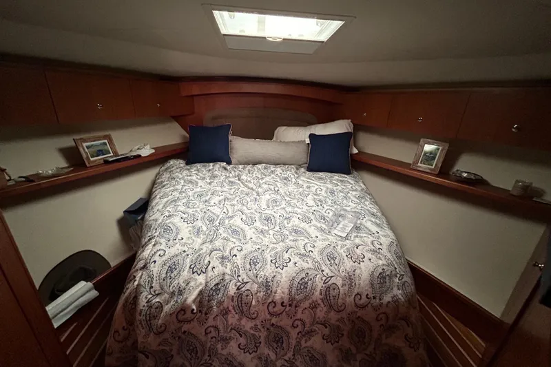 Follow That Stern Ix Yacht Photos Pics Cozy bedroom interior of 2007 Tiara Yachts 3900 Convertible with patterned bedding and wooden cabinets.