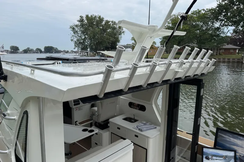  Yacht Photos Pics 2025 Extreme Boats 986 Game King with rod holders, docked by a scenic waterfront.