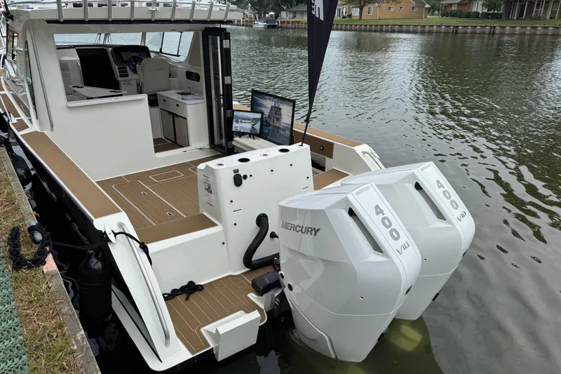  Yacht Photos Pics 2025 Extreme Boats 986 Game King with dual Mercury 400 engines docked on a calm waterway.