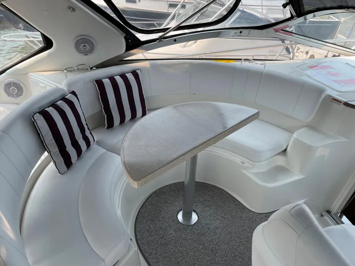  Yacht Photos Pics 2003 Regal 3860 Commodore interior with white seating, striped pillows, and a central table.