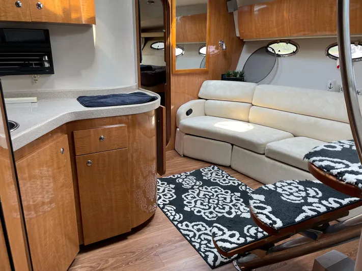  Yacht Photos Pics 2003 Regal 3860 Commodore yacht interior with beige sofa, wooden cabinetry, and patterned rugs.