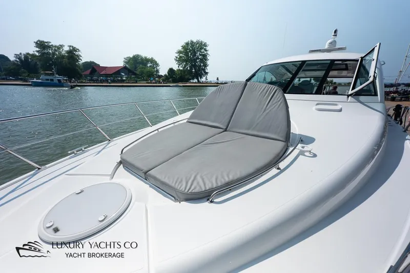  Yacht Photos Pics 2015 Cruisers Yachts 540 with sunpad, docked by a scenic waterfront.