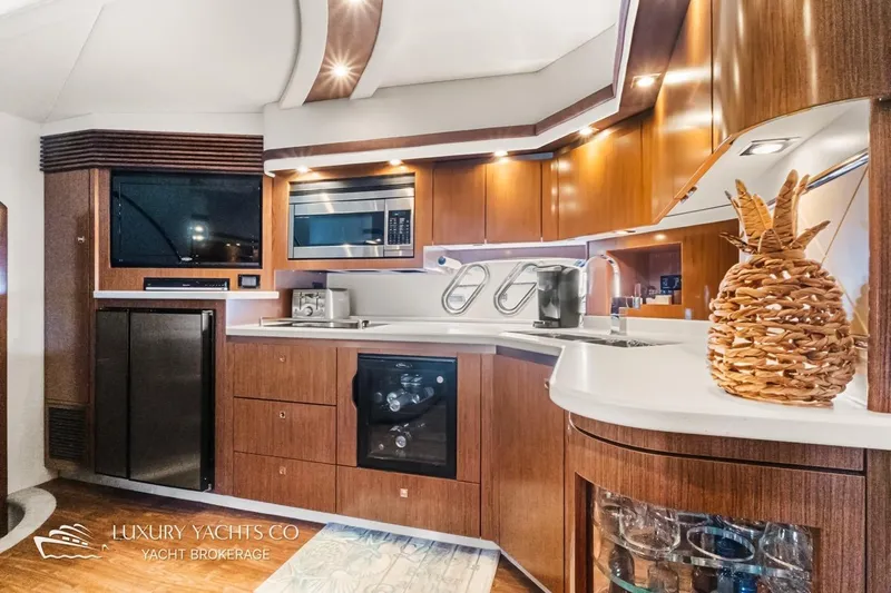  Yacht Photos Pics Luxurious 2015 Cruisers Yachts 540 kitchen with modern appliances and elegant wood cabinetry.