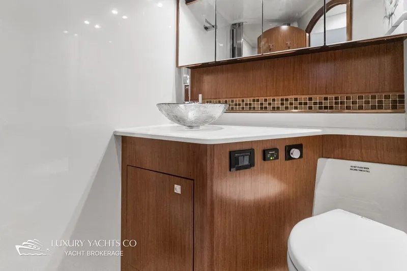  Yacht Photos Pics Luxurious bathroom in 2015 Cruisers Yachts 540, featuring modern sink and elegant wood cabinetry.