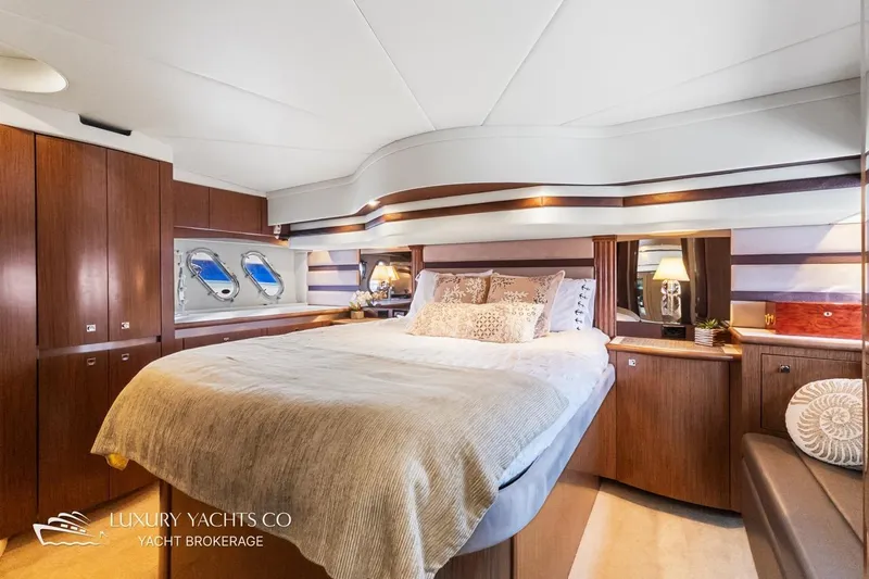  Yacht Photos Pics Luxurious 2015 Cruisers Yachts 540 bedroom interior with elegant wood finishes and cozy bedding.