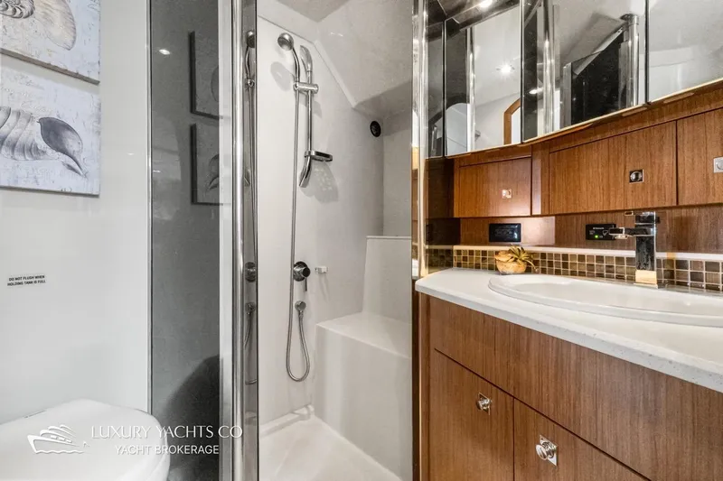  Yacht Photos Pics Luxurious bathroom in 2015 Cruisers Yachts 540, featuring modern fixtures and elegant wood cabinetry.