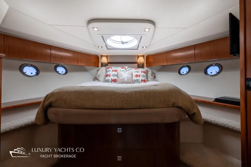  Yacht Photos Pics Luxurious 2015 Cruisers Yachts 540 bedroom interior with elegant wood finish and cozy bedding.