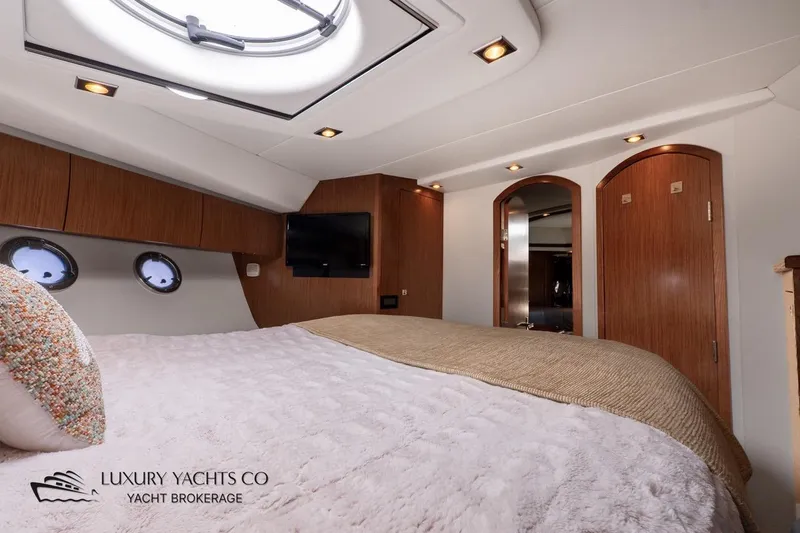  Yacht Photos Pics Luxurious 2015 Cruisers Yachts 540 bedroom interior with elegant wood finishes and cozy bedding.