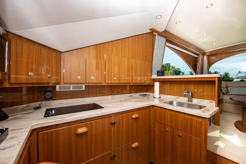 Catfish Yacht Photos Pics Luxurious kitchen interior of 2021 Viking 44 Convertible yacht with wooden cabinetry.