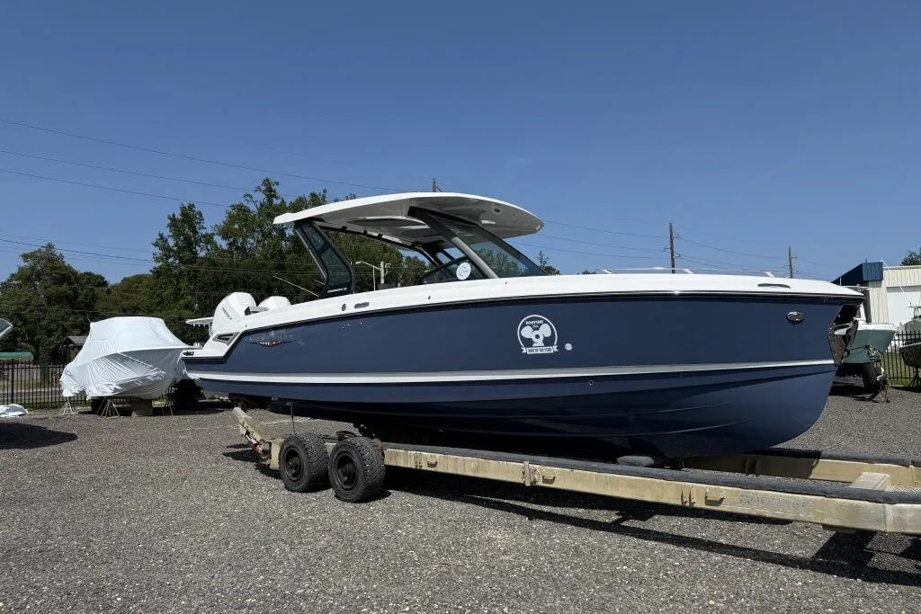 2026 Monterey Elite 30 OB boat on trailer, blue hull, outdoor display.