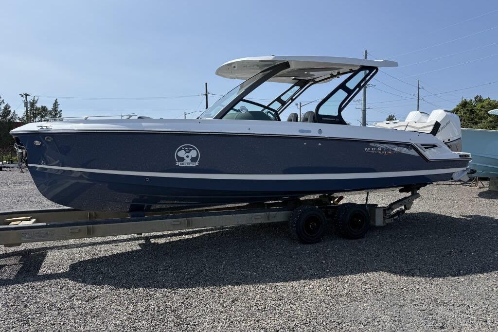 2026 Monterey Elite 30 OB boat on trailer, parked outdoors under clear sky.