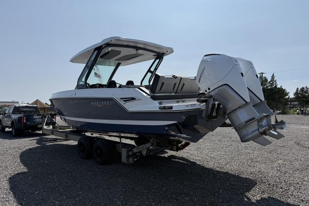 2026 Monterey Elite 30 OB boat on trailer with dual outboard motors.