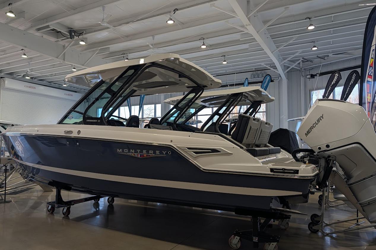 2026 Monterey Elite 30 OB boat displayed indoors with Mercury outboard engine.