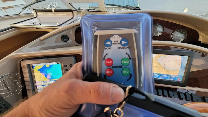  Yacht Photos Pics Hand holding remote control in 2003 Sea Ray 390 Motor Yacht cockpit with navigation screens.