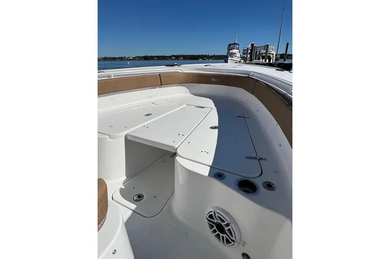 Wrecking Ball Yacht Photos Pics 2023 Sea Hunt Ultra 305 SE boat interior with seating and storage, docked by the water.