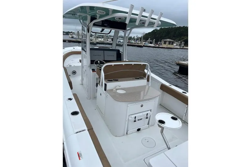 Wrecking Ball Yacht Photos Pics 2023 Sea Hunt Ultra 305 SE boat interior with helm, seating, and Garmin displays at a marina.