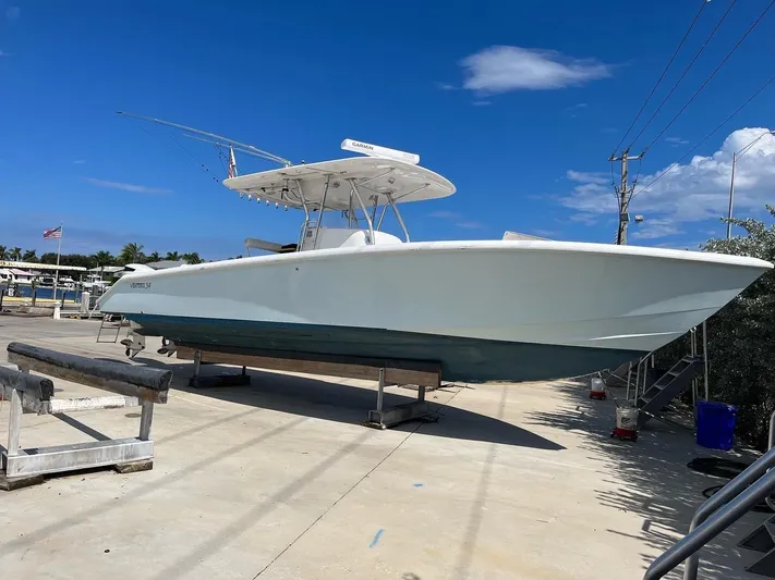Growing Grass Yacht Photos Pics 2004 Venture 34 Center Console boat on a dry dock under a clear blue sky.