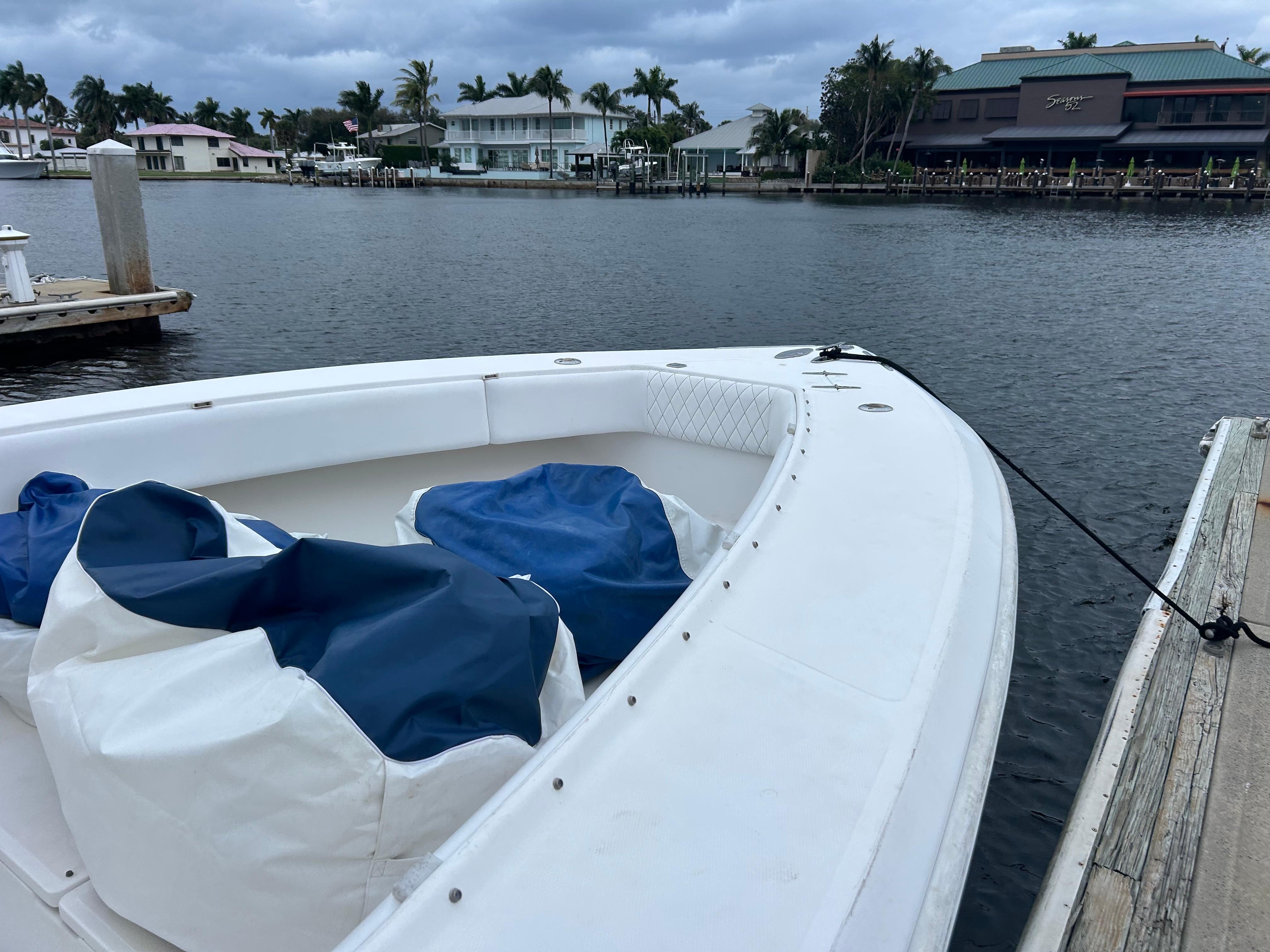 2004 Venture 34 Center Console boat docked by waterfront homes.