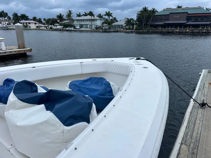 Growing Grass Yacht Photos Pics 2004 Venture 34 Center Console boat docked by waterfront homes.