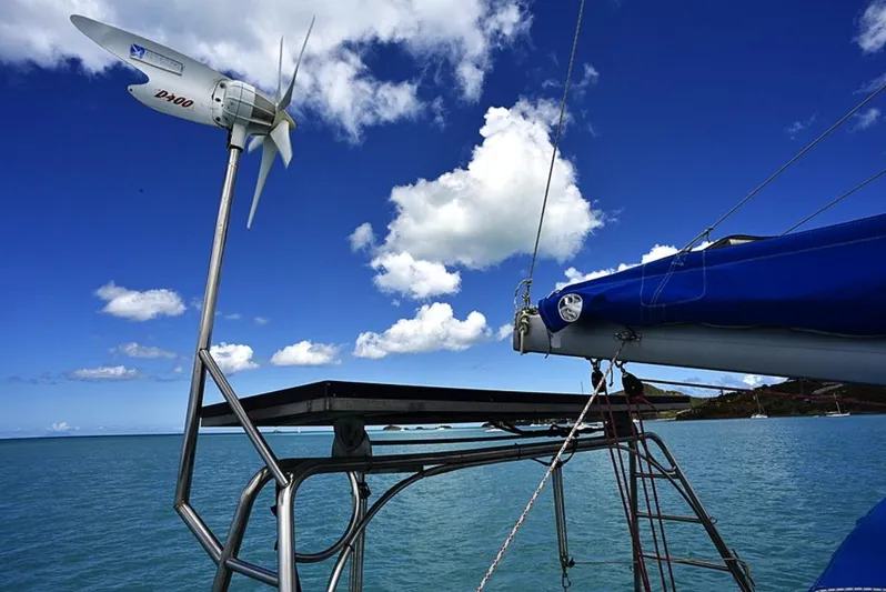 Mersea Yacht Photos Pics Sailboat Fountaine Pajot Athena 38, 1997, with wind turbine against blue sky and ocean backdrop.