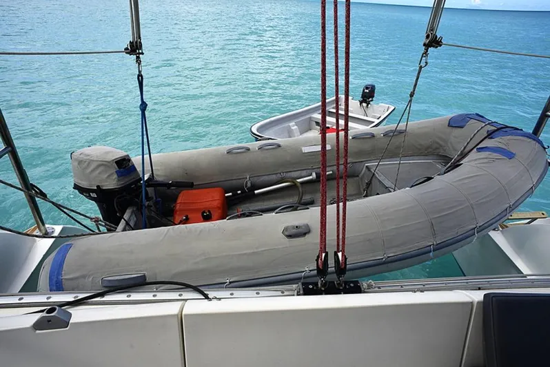Mersea Yacht Photos Pics Inflatable dinghy on Fountaine Pajot Athena 38 catamaran, 1997, anchored in turquoise waters.
